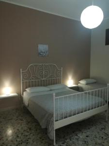 シラクーサにあるApartment Casa Francescaのベッドルーム1室(ベッド2台、壁に照明2つ付)