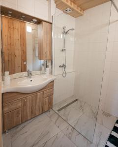 ein Bad mit einem Waschbecken und einer Dusche in der Unterkunft Volcz Családi Birtok in Ajka