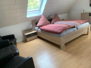 um quarto com uma cama com almofadas cor-de-rosa em Boardinghouse Saargau em Überherrn