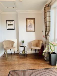 a living room with two chairs and a table at Bojangles Guest House in Gretna Green