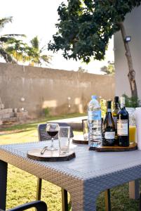uma mesa com garrafas de vinho e copos em Cristina´s Home Natural Feelings em Matola