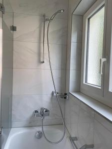 y baño con ducha y bañera. en Haus Pramalinis - Mosbacher, en Davos