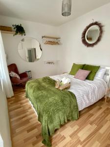 een slaapkamer met een groot bed en een groene deken bij Stay in AUX, feel at home ! 2 room apartment central incl all you need for 4 person, 24H check in, PKW parking only in Augsburg