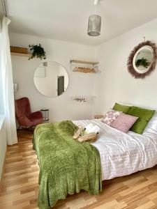 een slaapkamer met een bed met een groene deken erop bij Stay in AUX, feel at home ! 2 room apartment central incl all you need for 4 person, 24H check in, PKW parking only in Augsburg