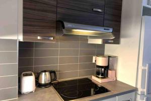 a kitchen with a stove and a coffeemaker at Modern Apartment with Sauna Nearby Airport in Vantaa