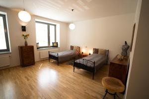 Sala de estar con 2 camas, mesa y silla en Black Field Apartment, en Brno