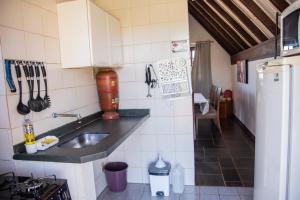 a small kitchen with a sink and a refrigerator at Chalés da Cuesta in Pardinho
