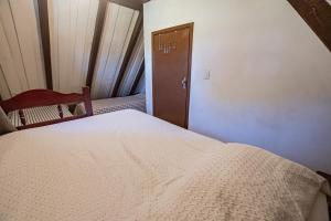 a bedroom with a bed and a chair and a door at Chalés da Cuesta in Pardinho
