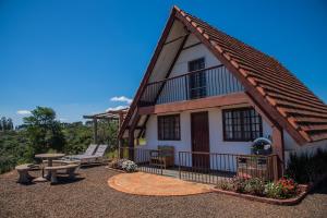 a house with a table and a picnic table in front of it at Chalés da Cuesta in Pardinho