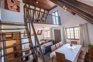 a living room with a spiral staircase and a table at Chalés da Cuesta in Pardinho