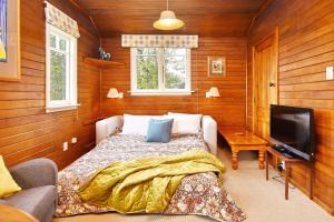 a bedroom with a bed and a television in it at Otahuna Hideaway - Christchurch Holiday Homes in Tai Tapu +38 photos