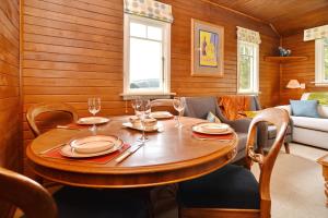 une salle à manger en bois avec une table et des chaises en bois dans l'établissement Otahuna Hideaway - Christchurch Holiday Homes, à Tai Tapu