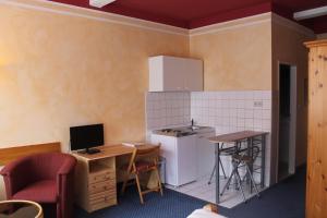 a kitchen with a refrigerator, stove, microwave and a table at City Apartment Hotel Hamburg in Hamburg