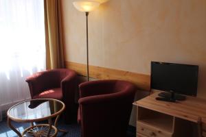 a hotel room with two chairs and a television at City Apartment Hotel Hamburg in Hamburg