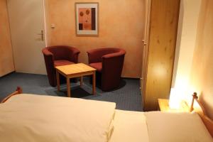 a hotel room with two beds and a table at City Apartment Hotel Hamburg in Hamburg