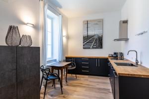 a kitchen with black cabinets and a table and a sink at Villa Bertholini in Bad Ischl