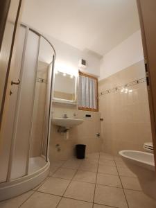een badkamer met douche, wastafel en toilet bij Snowflake Apartment in Livigno
