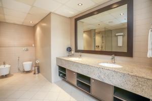 a bathroom with two sinks and a mirror at Luxury residential apartments located in Anantara area , pool , beach , free parking in Dubai
