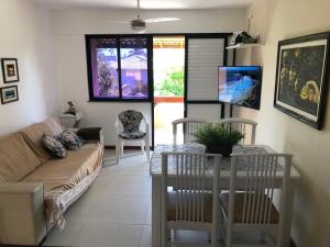 a living room with a couch and a table at 2 Suítes, Guarajuba, piscina frente mar in Guarajuba