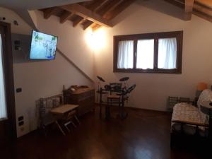 uma sala de estar com uma mesa e uma televisão na parede em Grande appartamento I Faggi em Abetone