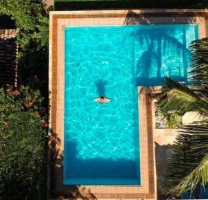 a person swimming in a swimming pool at Royal Turquesa Boutique Hotel in Búzios