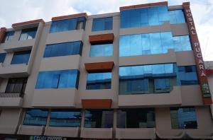 un edificio de oficinas con ventanas azules en Hostal Pucará, en Loja
