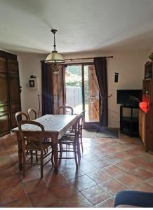 uma sala de jantar com uma mesa e cadeiras num quarto em La Petite Jeannette em Lans-en-Vercors