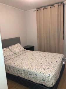 1 dormitorio con cama y cortina en Qurpawasi en Lima