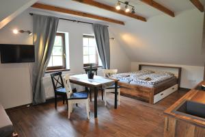 a bedroom with a bed and a table and chairs at Apartmány U Fibichů in Orlické Záhoří 