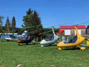 tres pequeños aviones estacionados en el césped en un campo en Centre aéro-récréatif ULM Québec (camping), en Berthierville