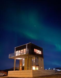 una casa con la aurora en el cielo en Converted Water Tower, en Grindavík