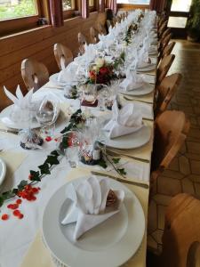 einen langen Tisch mit weißen Tellern und Servietten darauf in der Unterkunft Landgasthof Steiner in Matrei in Osttirol