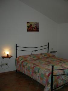 a bedroom with a bed and a table with a lamp at Casa Vacanze Fortini Mario in Piano Delle Pieve