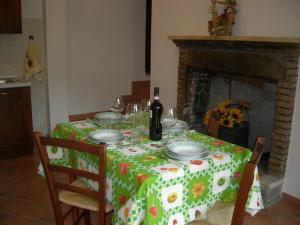 una mesa con un mantel verde y blanco con copas de vino en Casa Vacanze Fortini Mario, en Piano Delle Pieve