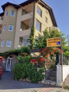 Un edificio con flores y un cartel delante. en Apartment Mario, en Livno