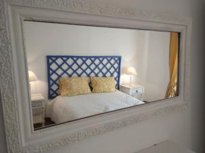 a mirror reflecting a bed in a bedroom at Estevas de Monsaraz in Monsaraz