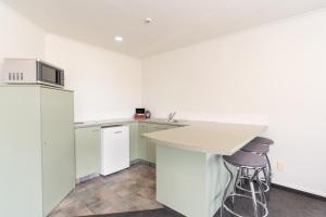 an empty kitchen with a counter and two stools at Alexandra Heights Motel in Alexandra