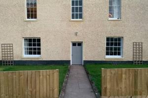 a building with a white door and a fence at Countryside Annexe, with hottub, sleeps up to 4 in Durston