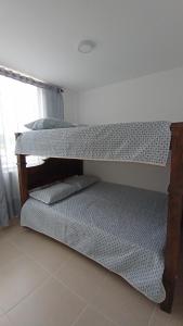 two bunk beds in a room with a window at Acogedor Apartamento en Armenia, totalmente amoblado. in Armenia