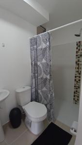a bathroom with a toilet and a shower curtain at Acogedor Apartamento en Armenia, totalmente amoblado. in Armenia