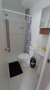a white bathroom with a toilet and a sink at Acogedor Apartamento en Armenia, totalmente amoblado. in Armenia