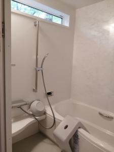 a white bathroom with a shower and a tub at c o p s e h a u s-Vacation STAY 97230 in Azumino