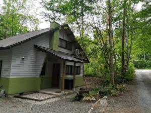 a green and white house in the woods at c o p s e h a u s-Vacation STAY 97230 in Azumino