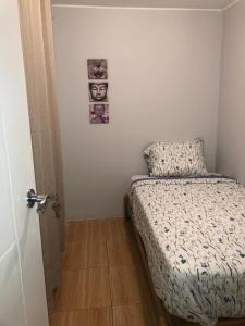 - une petite chambre avec un lit et une photo sur le mur dans l'établissement Qurpawasi, à Lima