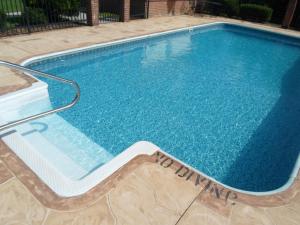 a large swimming pool with blue water at Baymont by Wyndham Adairsville in Adairsville