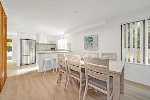 a kitchen and dining room with a table and chairs at Husky 56 Beachfront Villa's in Huskisson