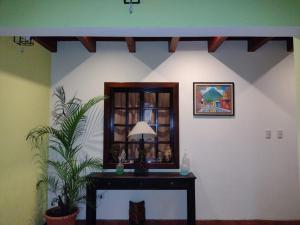 a room with a mirror and a table with a plant at La casita de Angie in Antigua Guatemala