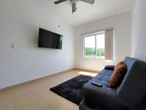 a living room with a couch and a flat screen tv at Casa Punta Estrella in Playa del Carmen