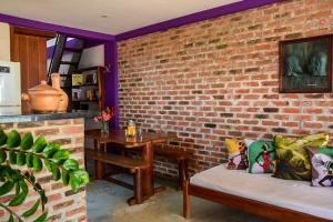 una pared de ladrillo con un banco y una mesa en Casa Sol Nascente, en Itacaré