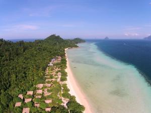 a beach with a view of the ocean and mountains at The Sevenseas Resort Koh Kradan in Koh Kradan